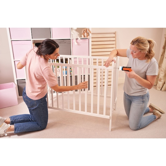 HEXDRIVER Cordless Furniture Assembly Tool / Screwdriver being used by two people to assemble a crib.