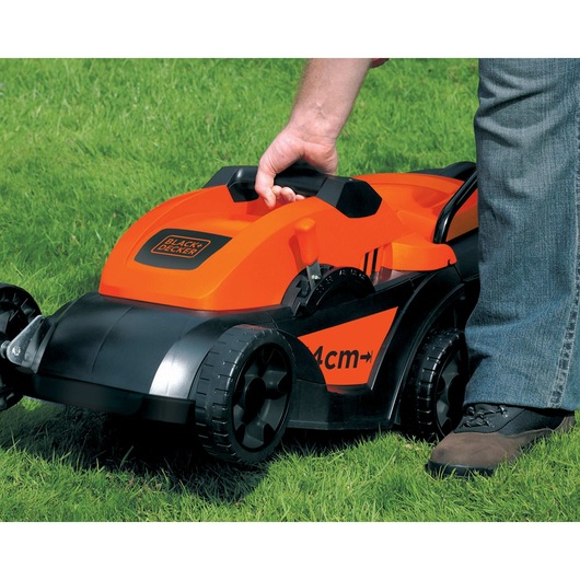 left diagonal view of the black and decker lawn mower GR3800 being held by a male hand