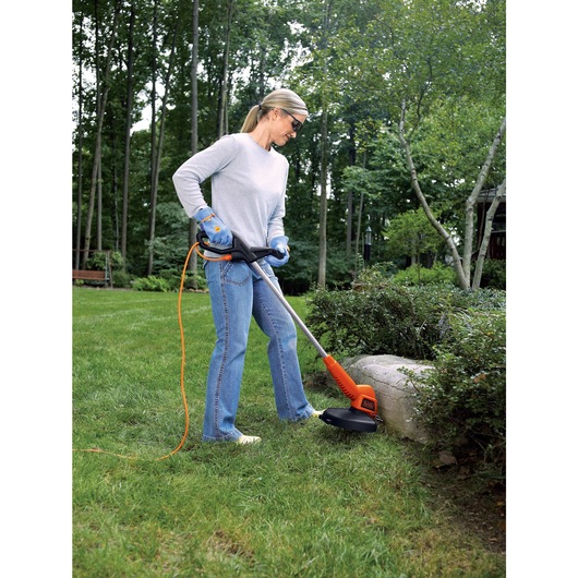 4.4 AMP 13 inch 2 in 1 Trimmer Edger being used by a person on grass.